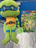 Leonardo plush and April O'Neal action figure on card shown side by side