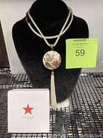 Front view of vintage cream color cloisonné butterfly pendant necklace on black bust with Macy's gift box next to it.