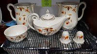 Full set of Hall's Superior Quality kitchenware including tea set, carafes, bowl, and shakers with visible detail of the leaf pattern.