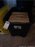 Large plastic tub filled with vinyl records, viewed from above.