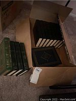 Box with multiple Harvard Classics volumes and Joe Haldeman signed first edition book.