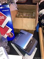 Polaroid One600 instant camera in metallic gray with pack of 600 instant film box nearby