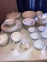 Full view of stacked plates, cups, bowls and serving pieces on a table