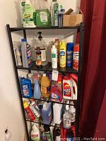 Full view of black shelving unit with multiple shelves holding various household cleaning and polish products.