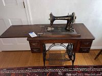 Full front view of oak table with sewing machine extended and drawers visible