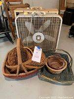 Photo showing multiple woven baskets stacked inside each other in front of a white box fan, baskets vary in size and are in natural woven materials.