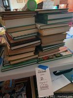 Stack of about 25 hardcover books related to daffodils and lilies, showing bindings and spines in various colors.