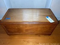 Front view of closed chest showing medium brown finish and front panel.