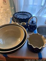 Full set arranged on white surface with light through window, includes bowls, sugar bowl, and creamer