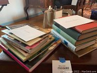 Two piles of books on a wooden table, titles visible about orchids and houseplants.
