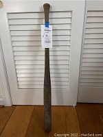 Full view of vintage wooden softball bat by Hillerich & Bradsby showing length and wear marks
