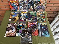 All 13 Batman comics stacked with covers visible showing various issues and designs.