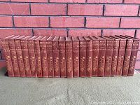Full set of 24 volumes in row showing burgundy cloth bindings and gilt stamping.