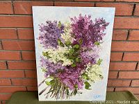Front view of the floral oil painting showing detailed texture, color, and signature.