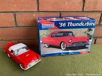Diecast 1956 Ford Thunderbird model car next to the Monogram model kit box showing front and side view