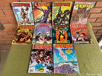 Front view of 10 Eerie magazines with colorful horror and science fiction cover art, arranged in two rows on a green surface against brick background.