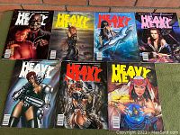 Seven vintage Heavy Metal magazines laid out in two rows, showing detailed adult science fiction and fantasy cover art