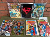 Full lot view showing 7 vintage Superman and related comics, some polybagged