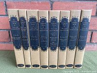 Front view of 10 hardcover books in tan cloth covers with black and gold spine labels. Each spine reads The Complete Works of William Shakespeare Stratford Edition and lists individual plays included in volume.