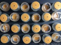 Top view of 26 clear plastic chair leg protectors each with attached beige felt pads on the bottom to protect floors.