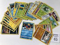 Top view showing 30 various Pokémon trading cards face-up, displaying different Pokémon characters in color.