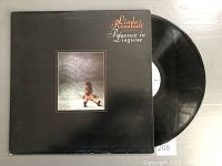 Front cover of Prisoner in Disguise vinyl album by Linda Ronstadt, partially showing black vinyl LP record