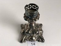 Full view of the ornate silver plated candlestick showing the pierced pattern holder and ornate base details.