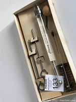 Top view of thermometer set in original box showing all items including thermometers, metal clips, and wooden tool.