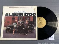 Front cover of Album 1700 by Peter, Paul & Mary displayed next to vinyl record showing Warner Bros. yellow label.