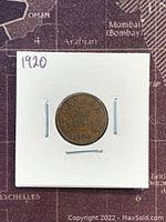 Front side of the 1920 Canadian one cent coin showing denomination and maple leaves.