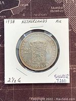 Reverse side of 1938 Netherlands 2½ Gulden silver coin showing crowned shield, denomination, and date in holder.