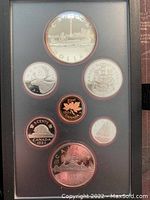 Top view of the 1984 Canadian silver proof coin set showing 7 coins sealed in a black display case.