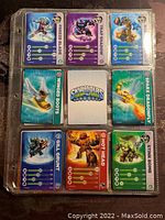 Page showing 9 Skylanders trading cards including Freeze Blade, Trap Shadow, Winged Boots, Sparx Dragonfly, Gill Grunt, Hot Head, and Stink Bomb in plastic sheet protector.