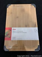 Front view of bamboo cutting board with packaging label showing brand and item name.