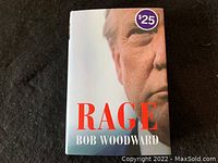 Front cover of 'Rage' hardcover book by Bob Woodward featuring close-up photo of Donald Trump, title in bold red font and a price sticker.