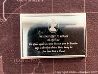 Front side of silver bar showing Queen Elizabeth II profile and inscription about 1957 state visit to France.