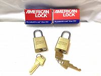 Two American Lock Series 5530 solid brass padlocks with keys and packaging boxes, displayed on white background.
