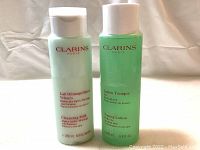 Two bottles side by side: Cleansing Milk in white bottle and Toning Lotion in green bottle, both 200ml size.