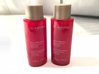 Front view of two red bottles labeled Clarins Paris Multi-Intensive Super Restorative Treatment Essence 50ml each