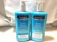 Two bottles of Neutrogena Hydro Boost Body Gel Cream with white pump dispensers, one for normal to dry skin and one for sensitive and dry skin, both 453 grams.