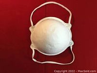 Front view of a white FFP2 face mask with elastic straps on red background.