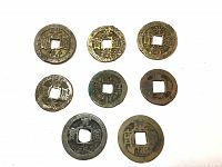 Top-down photo showing all seven ancient Chinese coins in varied patinas, each round with square center hole and inscriptions.