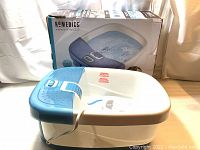 Homedics footbath foot massager with original packaging box in background.