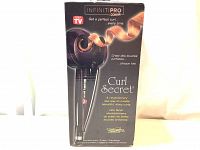 Front and side view of the boxed Conair InfinitiPro Curl Secret Ionic Curling Iron showing branding and product design.