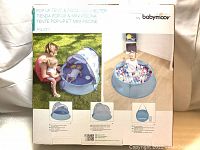 Box front showing the Babymoov Aquani pop up tent and kiddie pool in use with a baby and mother.