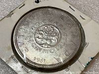 Obverse side of the coin showing floral design with the year 1964 and Canadian text.