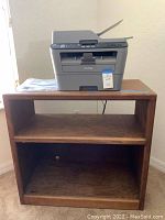 Brother MFC-L2680W printer sitting on top of oak stand with a middle shelf.