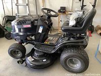 Side view showing mower deck, turf tires, steering column and seat.