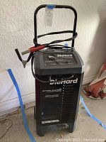 Full view of the DieHard battery charger showing the unit's size, attached cables, clamps, and handle.