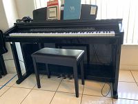 Front view showing piano, bench, sheet music and headphones